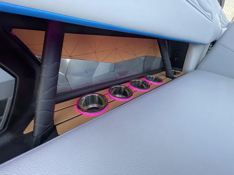 Slide: The Image of 2025 Nautique Super Air Nautique G25 interior with illuminated cup holders and modern design. - 21