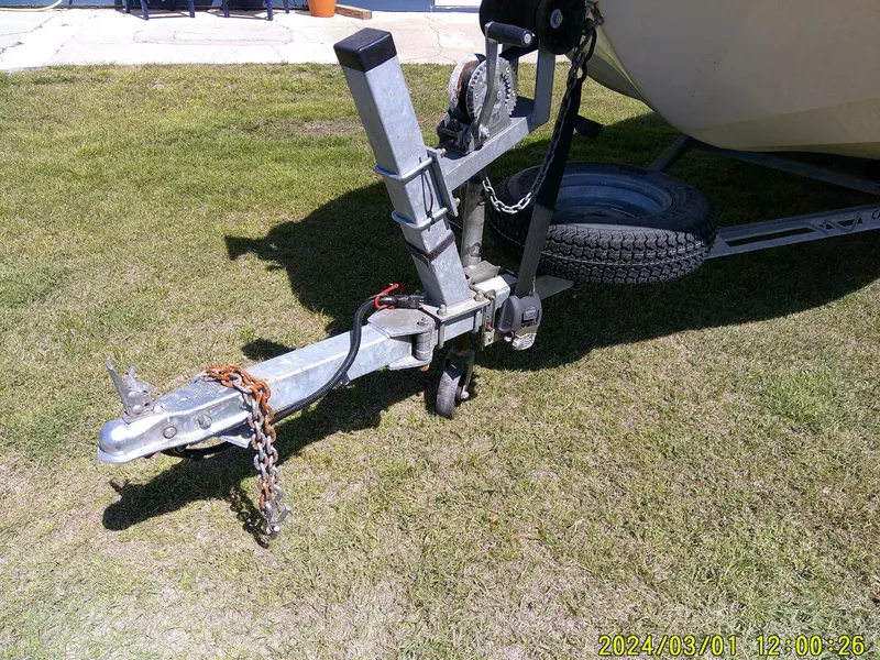 Slide: The Image of Trailer hitch of a 2016 Carolina Skiff JVX16 on grass, with safety chain attached. - 4