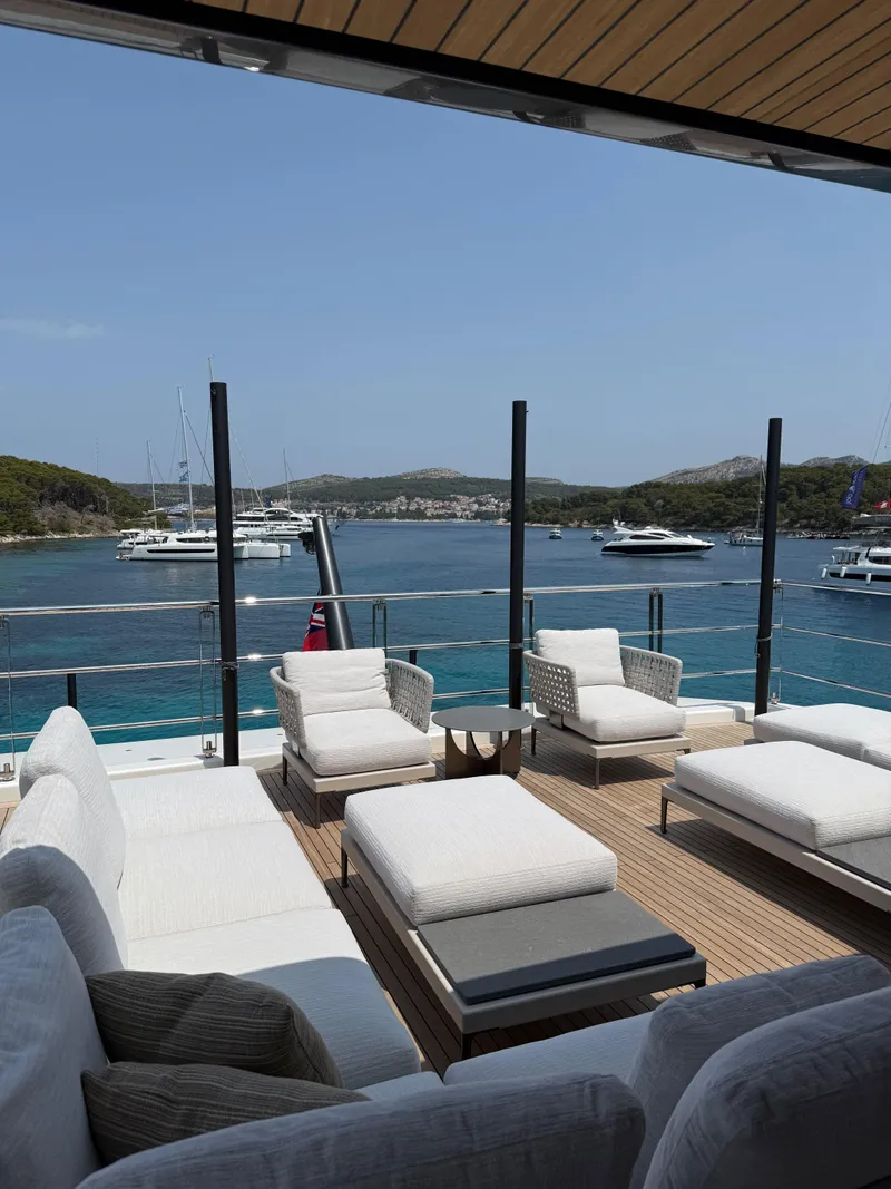 Slide: The Image of Luxurious yacht deck with modern seating, overlooking serene blue waters and distant boats. - 8