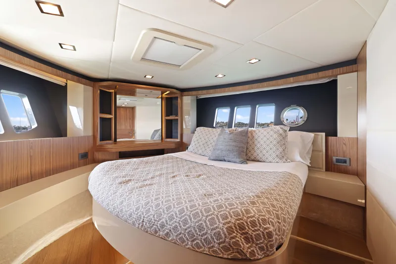 Slide: The Image of Luxurious yacht bedroom with modern design, featuring a cozy bed and elegant wood accents. - 19
