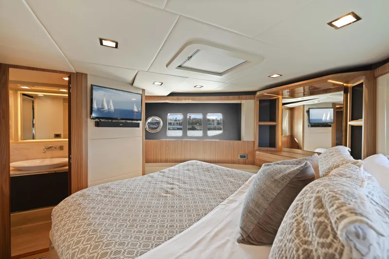 Slide: The Image of Luxurious yacht bedroom with modern decor, featuring a large bed, TV, and scenic windows. - 21