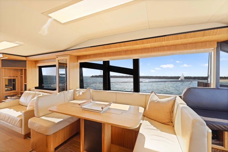 Slide: The Image of Luxurious yacht interior with ocean view, featuring elegant seating and wooden accents. Absolute Fly Co Ownership 2015. - 9