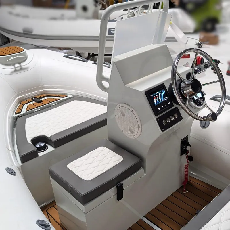 Slide: The Image of 2025 Tide Craft San Juan 11 boat interior with modern steering console and cushioned seating. - 11