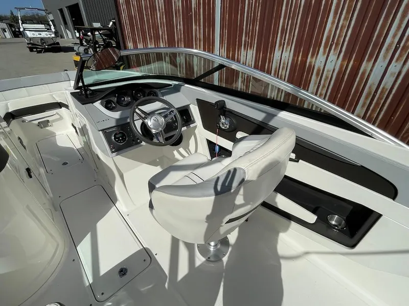 Slide: The Image of 2016 Sea Ray 240 Sundeck boat interior with steering wheel and seating. - 10