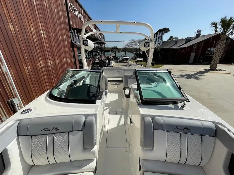 Slide: The Image of 2016 Sea Ray 240 Sundeck boat with open cockpit and seating, docked near wooden buildings. - 14
