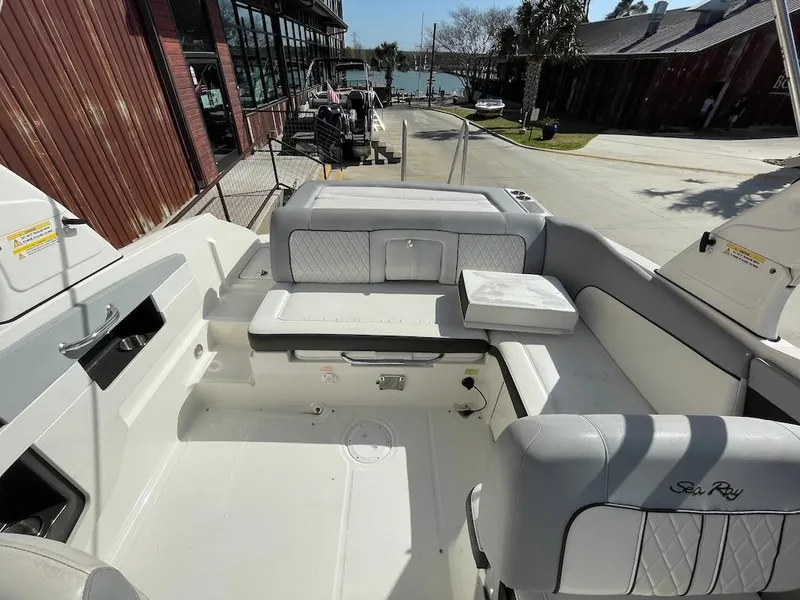Slide: The Image of 2016 Sea Ray 240 Sundeck boat interior with white seating and storage compartments. - 16