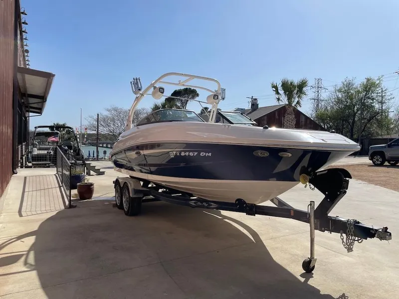 Slide: The Image of 2016 Sea Ray 240 Sundeck boat on trailer, parked outdoors. - 2