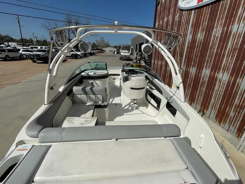 Slide: The Image of 2016 Sea Ray 240 Sundeck boat interior with seating and steering wheel, parked outdoors. - 6