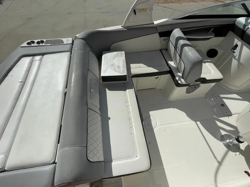 Slide: The Image of 2016 Sea Ray 240 Sundeck interior with white and gray seating, cup holders, and spacious layout. - 7