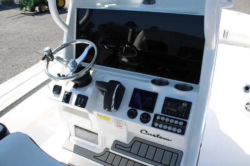 Slide: The Image of 2025 Tidewater 2500 Carolina Bay boat console with steering wheel and control panel. - 22
