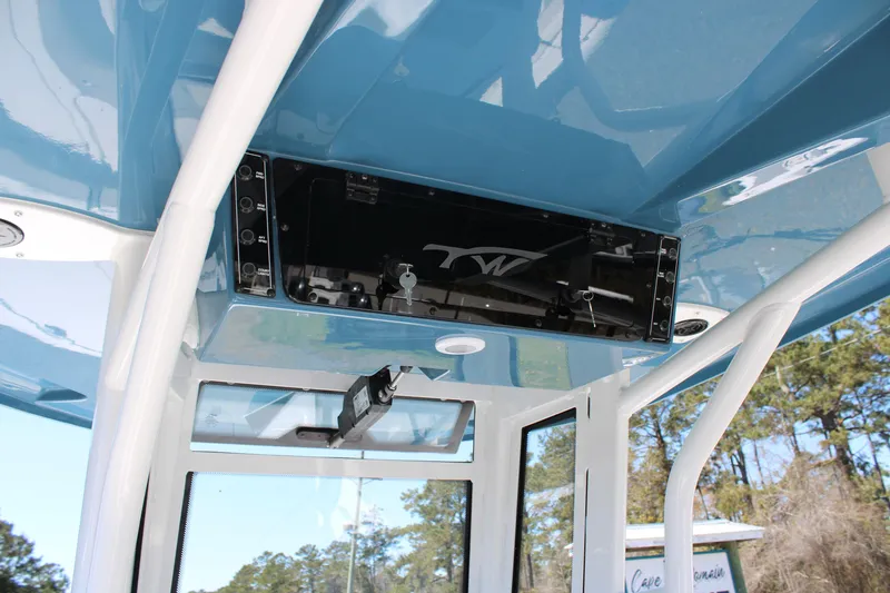 Slide: The Image of 2025 Tidewater 2500 Carolina Bay boat interior with blue ceiling and storage compartment. - 24