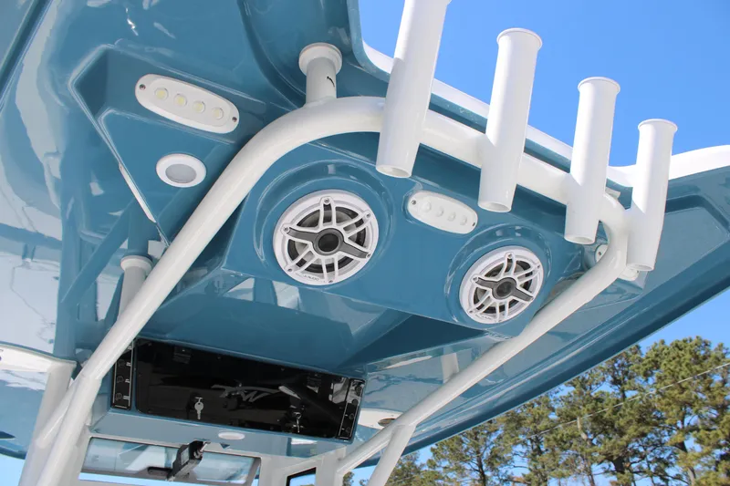 Slide: The Image of 2025 Tidewater 2500 Carolina Bay boat speakers and rod holders under blue canopy. - 25