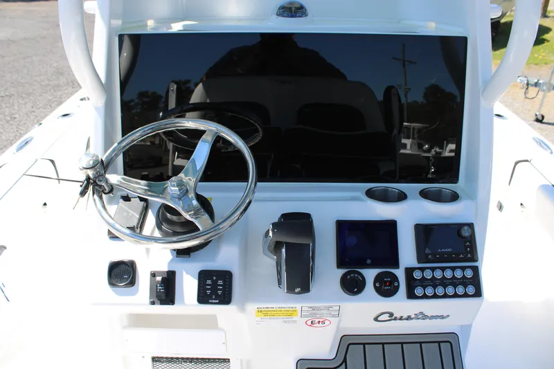 Slide: The Image of 2025 Tidewater 2500 Carolina Bay boat dashboard with steering wheel and controls. - 26