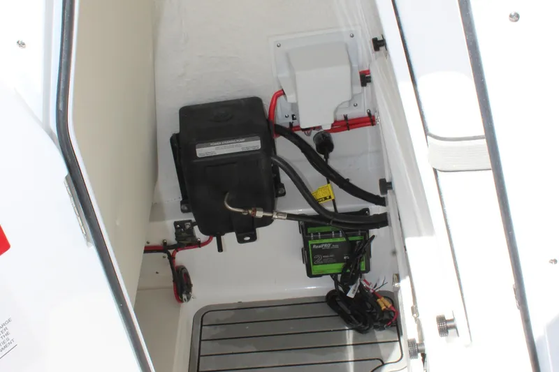 Slide: The Image of 2025 Tidewater 2500 Carolina Bay boat electrical compartment with battery and wiring. - 35