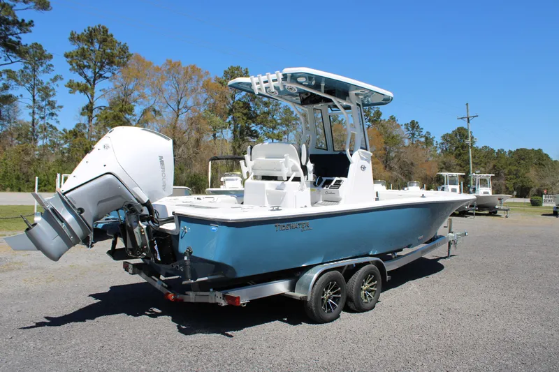 Slide: The Image of 2025 Tidewater 2500 Carolina Bay boat on trailer, blue hull, parked outdoors. - 6
