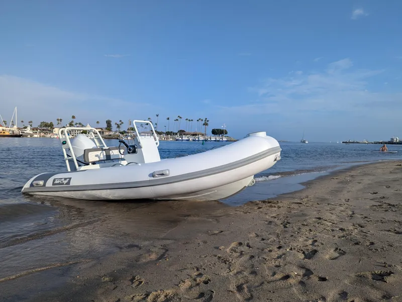 Slide: The Image of Tide Craft Catalina 13 boat on sandy beach, 2025 model, with ocean and palm trees in background. - 3