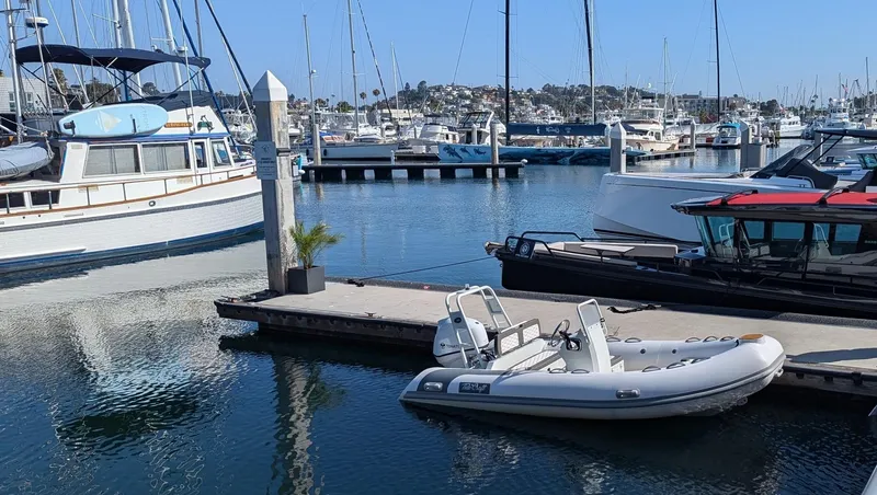 Slide: The Image of A 2025 Tide Craft Catalina 13 boat docked in a marina with other vessels. - 4