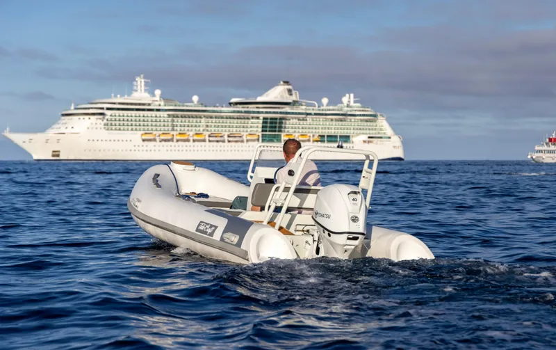 Slide: The Image of Tide Craft Catalina 13 boat on ocean, cruise ship in background, 2025 model. - 9