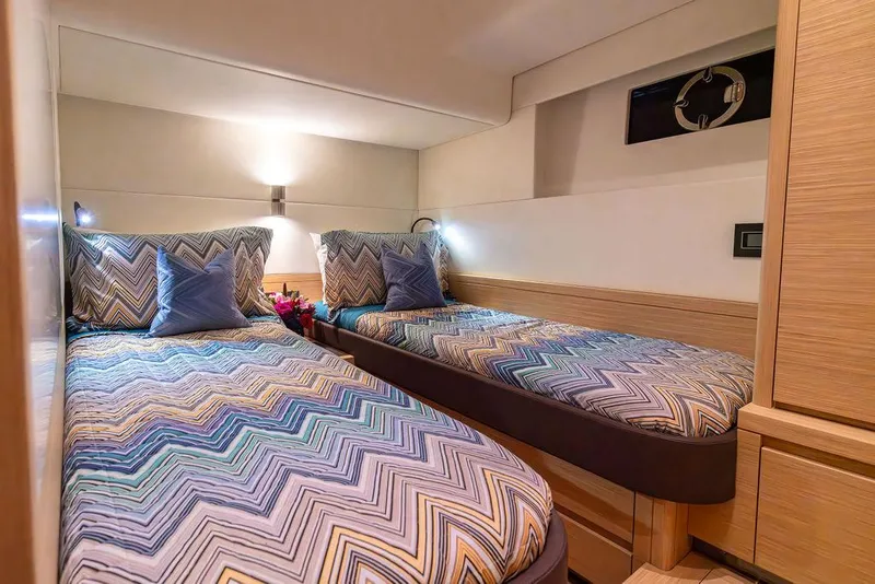 Slide: The Image of Twin beds in the 2023 Pardo Yachts Endurance 60 cabin, featuring chevron-patterned bedding. - 26
