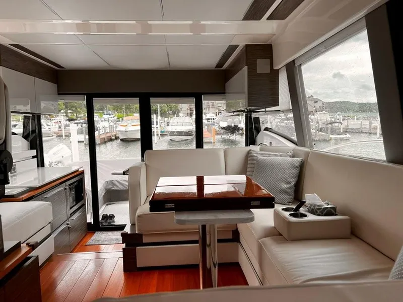 Slide: The Image of Interior of 2019 Tiara Yachts 490 Coupe with elegant seating and marina view. - 1