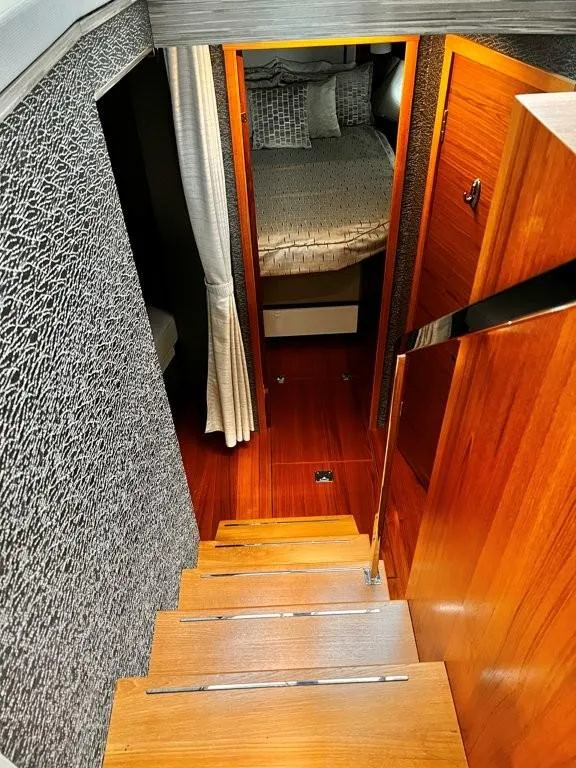 Slide: The Image of 2019 Tiara Yachts 490 Coupe interior with wooden stairs and cozy bedroom. - 15