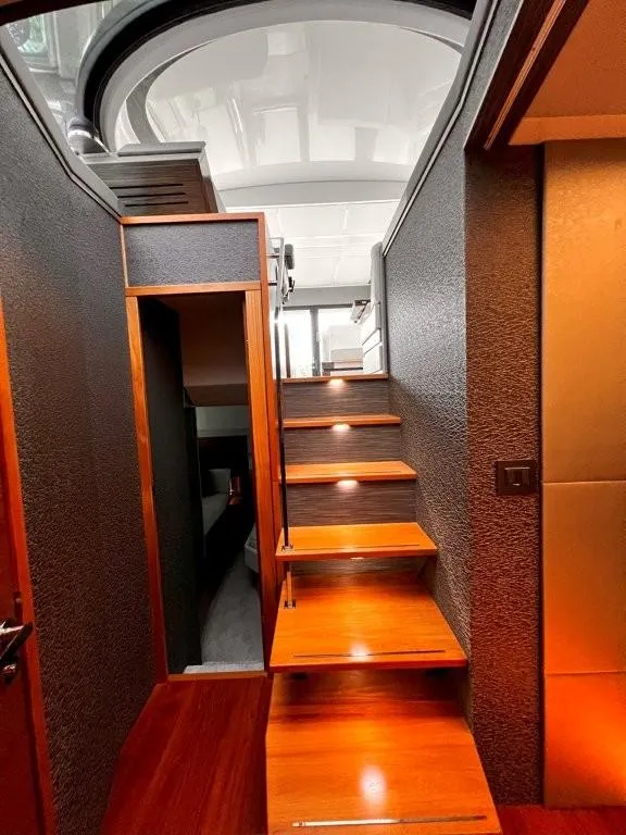 Slide: The Image of Staircase inside 2019 Tiara Yachts 490 Coupe, featuring sleek wood steps and modern lighting. - 16