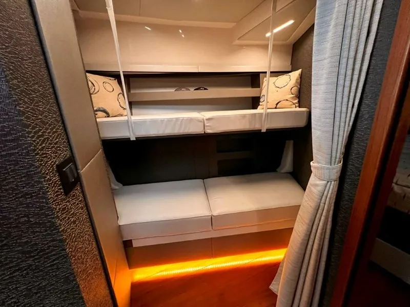 Slide: The Image of 2019 Tiara Yachts 490 Coupe interior with cozy bunk beds and ambient lighting. - 17