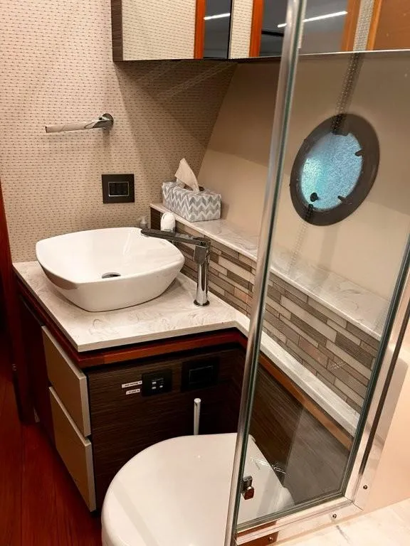 Slide: The Image of Luxurious bathroom in 2019 Tiara Yachts 490 Coupe with modern sink and porthole window. - 20