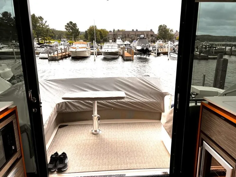 Slide: The Image of 2019 Tiara Yachts 490 Coupe interior view, overlooking marina with docked boats. - 9