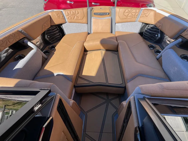 Slide: The Image of 2024 Nautique Super Air Nautique G25 Paragon interior with luxurious tan seating and cup holders. - 12