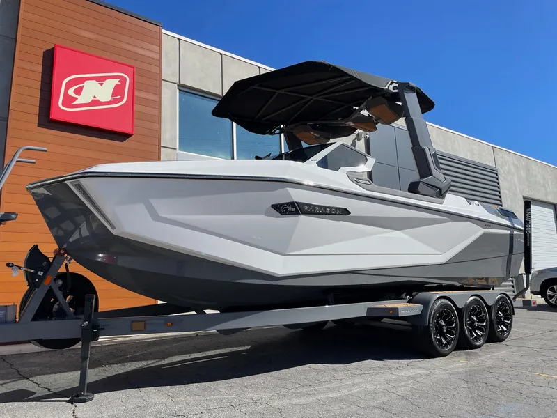 Slide: The Image of 2024 Nautique Super Air Nautique G25 Paragon boat on trailer, parked outside dealership. - 2