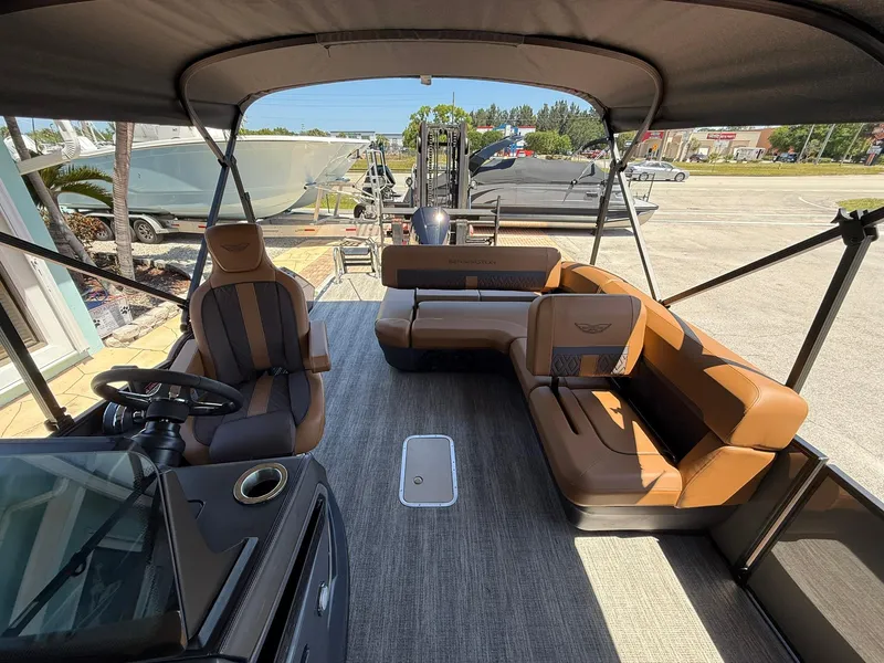 Slide: The Image of 2025 Bennington 24 MSB boat interior with brown seating and steering console. - 12
