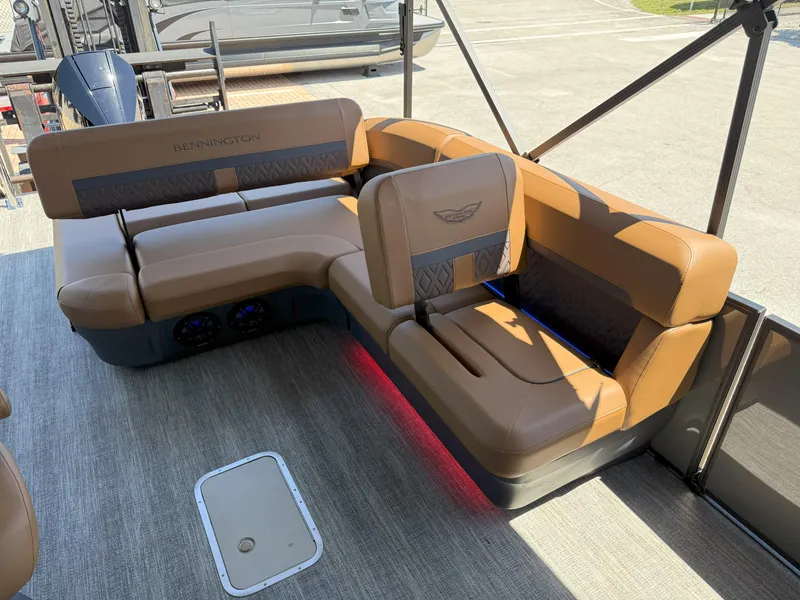 Slide: The Image of 2025 Bennington 24 MSB boat interior with brown leather seating and ambient lighting. - 14