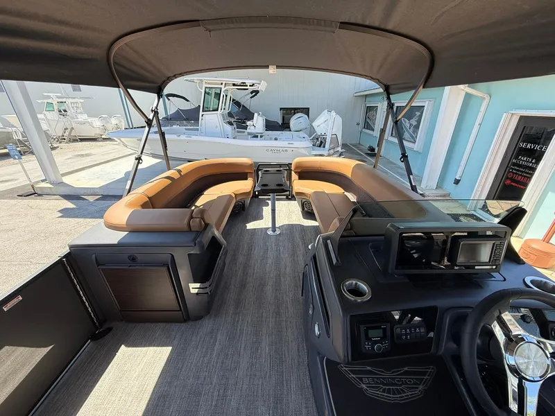 Slide: The Image of 2025 Bennington 24 MSB pontoon boat interior with tan seating and modern dashboard. - 17