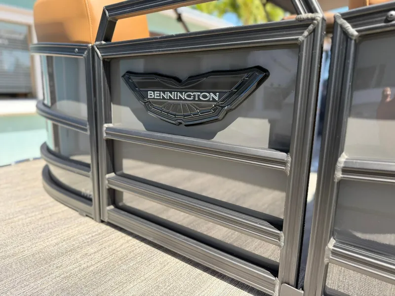 Slide: The Image of 2025 Bennington 24 MSB pontoon boat, close-up of logo and sleek design. - 2
