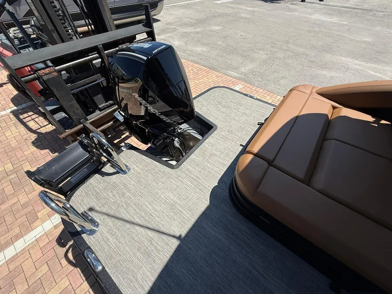 Slide: The Image of 2025 Bennington 24 MSB boat with motor and brown seating on a sunny day. - 3