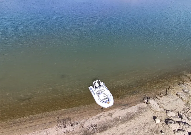Slide: The Image of Aerial view of 2025 Tide Craft Beaver 10 boat on a calm shoreline. - 1