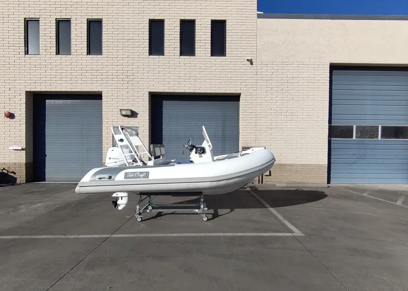 Slide: The Image of Tide Craft Beaver 10 boat, 2025 model, parked outside industrial building with blue doors. - 6