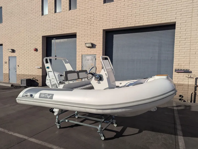 Slide: The Image of 2025 Tide Craft Beaver 10 inflatable boat on trailer, parked outside industrial building. - 7