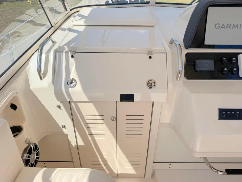 Slide: The Image of 2022 Grady-White Marlin 300 boat interior with Garmin navigation system and storage compartments. - 11