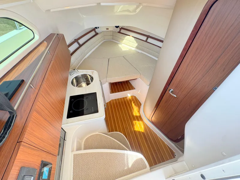 Slide: The Image of Interior of 2022 Grady-White Marlin 300 boat with kitchenette and seating area. - 12
