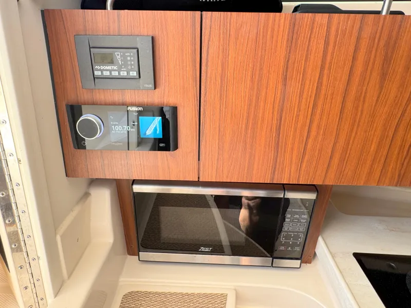 Slide: The Image of 2022 Grady-White Marlin 300 interior with microwave and control panels. - 17