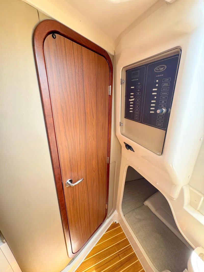 Slide: The Image of 2022 Grady-White Marlin 300 cabin interior with wooden door and control panel. - 19
