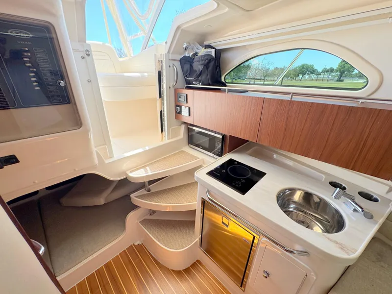 Slide: The Image of 2022 Grady-White Marlin 300 cabin interior with kitchenette and stairs. - 23