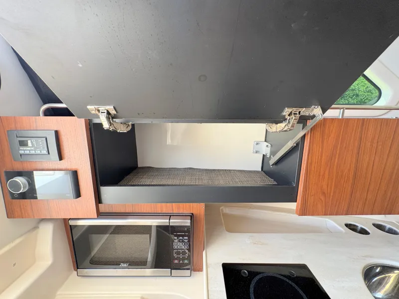 Slide: The Image of 2022 Grady-White Marlin 300 interior kitchen with microwave, stove, and storage cabinets. - 24