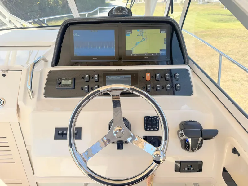 Slide: The Image of 2022 Grady-White Marlin 300 helm with dual navigation screens and steering wheel. - 29