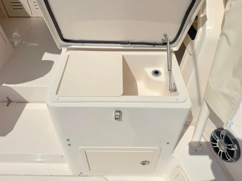 Slide: The Image of 2022 Grady-White Marlin 300 boat storage compartment with open lid and drain. - 38