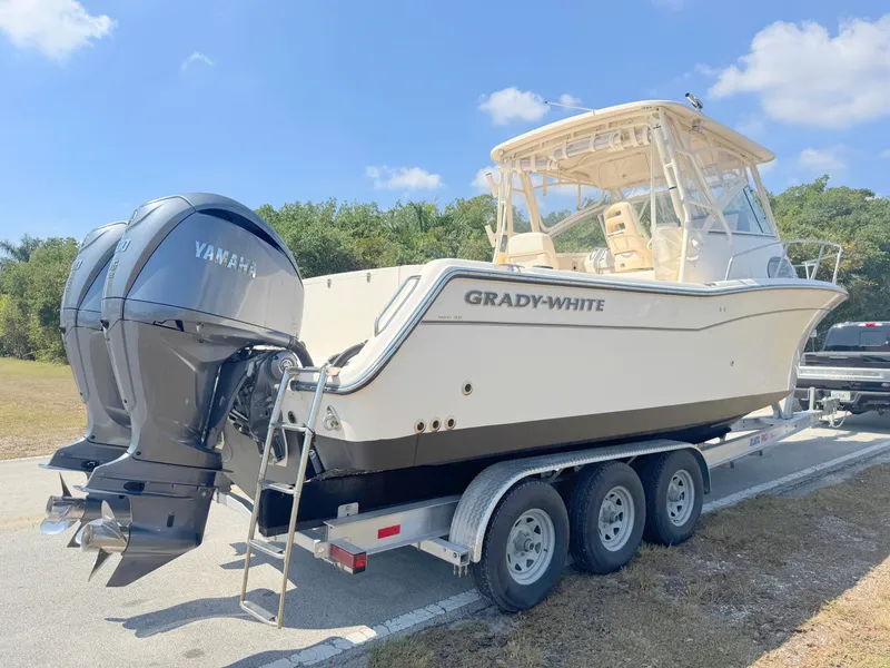 Slide: The Image of 2022 Grady-White Marlin 300 boat on trailer with Yamaha engines, parked outdoors. - 4