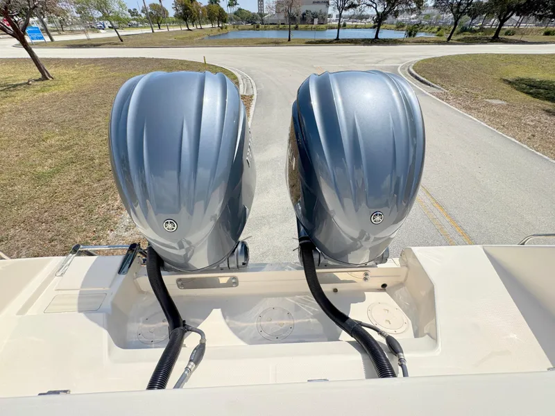 Slide: The Image of 2022 Grady-White Marlin 300 with dual outboard engines, parked near a scenic waterway. - 44