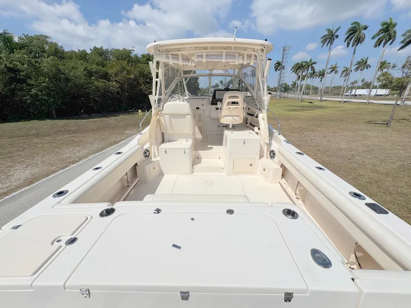 Slide: The Image of 2022 Grady-White Marlin 300 boat with spacious deck and seating, under clear skies. - 45